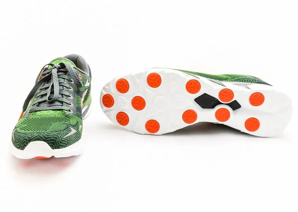Grüne und orangefarbene Laufschuhe mit Schnürsenkeln, isoliert auf weißen Studioaufnahmen — Stockfoto