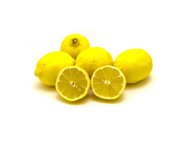 Studio shot pile of organic raw lemons with slice cuts isolated on white — Stockfoto