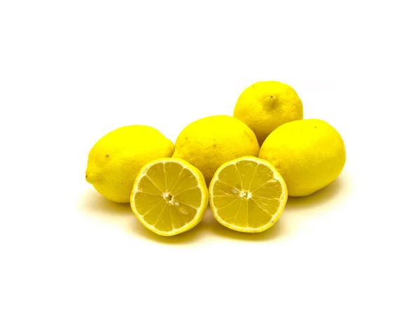 Studio shot pile of organic raw lemons with slice cuts isolated on white — Stock Photo, Image