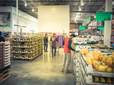 Coronavirus sırasında maske takan müşterilerle birlikte Costco 'da taze meyve ürünleri üretiyor.