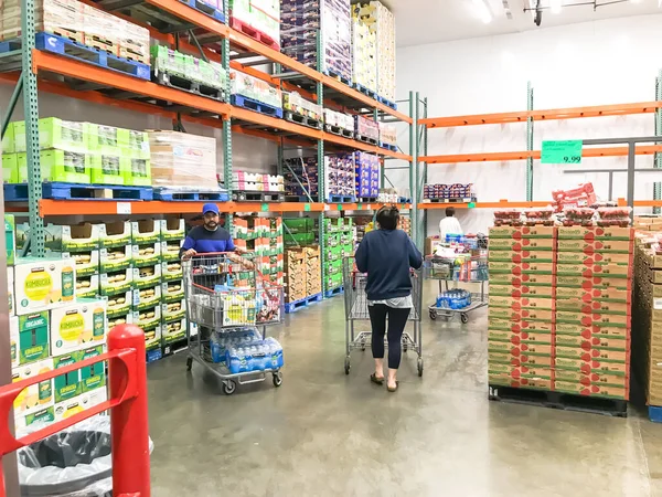 Coronavirus sırasında maske takan müşterilerle birlikte Costco 'da taze meyve ürünleri üretiyor.