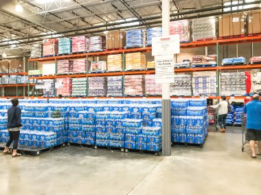 Coronavirus salgını sırasında müşteri alışverişiyle birlikte Costco 'da istiflenmiş şişe suyu.