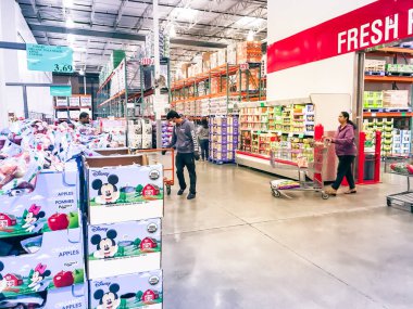 Coronavirus sırasında maske takan müşterilerle birlikte Costco 'da taze meyve ürünleri üretiyor.