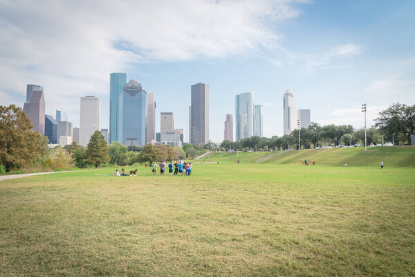 HOUSTON, TX, US-NOV 26, 2016: People enjoy outdoor activities at Eleanor Tinsley park in downtown Houston along Buffalo Bayou. Large green grass field lawn with modern skyscrapers in background