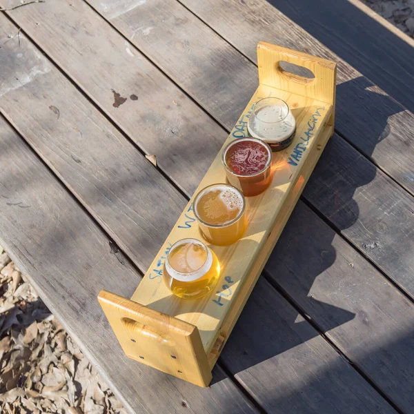Поднос для отбора проб пивных рейсов на открытом столе для пикника в саду пивоваренного завода в Техасе, США — стоковое фото