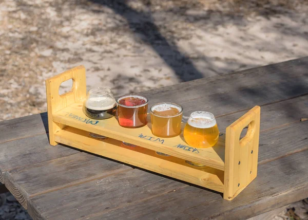 Špičkový náhled na tác se vzorkovacím vzorkem na venkovním dřevěném piknikovém stole v zahradě pivovaru v Texasu, USA — Stock fotografie