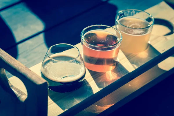 Draufsicht gemischte Fassbiere in Probiertablett auf hölzernem Picknicktisch einer Brauerei in Texas, USA — Stockfoto