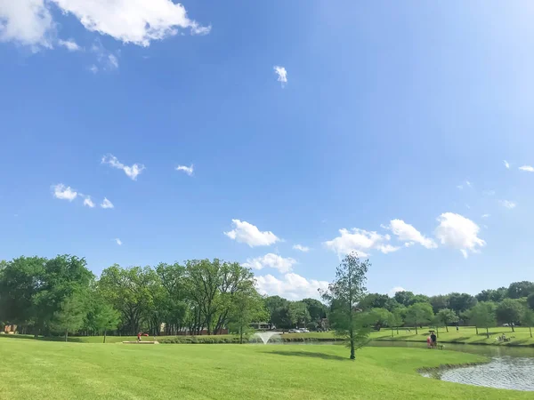 Neighborhood park with large pond and water fountain near Dallas, Texas, USA sunny cloud sky — Stock Photo, Image