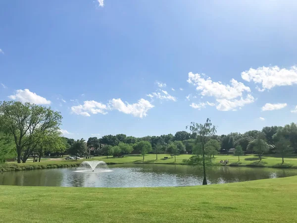 Neighborhood park with large pond and water fountain near Dallas, Texas, USA sunny cloud sky — Stock Photo, Image