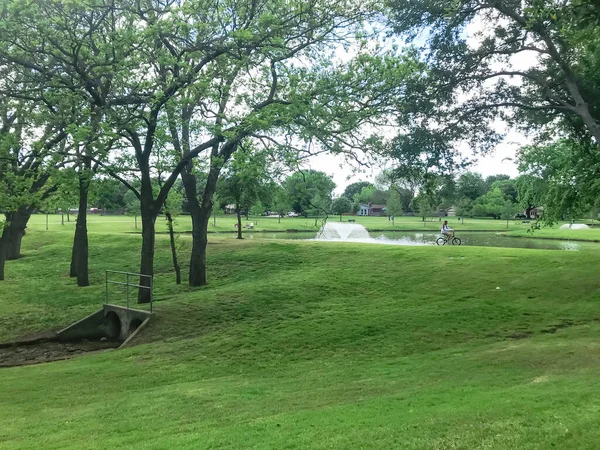 Residencial disfruta de andar en bicicleta en el parque del barrio con fuente de agua cerca de Dallas, Texas, EE.UU. — Foto de Stock