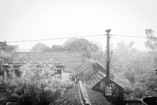 Ancienne maison de toit en tuiles et pylônes en béton sous de fortes pluies et du vent dans un village reculé du nord du Vietnam — Photo