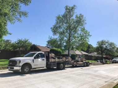 Dallas, Teksas, ABD banliyölerindeki yerleşim sokağında birden fazla inşaat makinesi ve ekipman var.