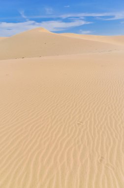 Geniş açı manzaralı çöl ve kum tepeleri dalgaları Vietnam Cuong, Phan Rang, Vietnam 'da mavi bulutlu gökyüzüne doğru uzanır.