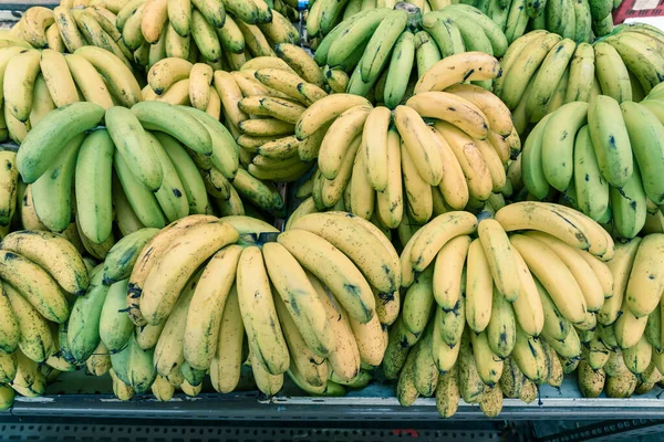 Racimos de plátanos ecológicos verdes y naturales maduración en el puesto de frutas en Geylang, Singapur — Foto de Stock