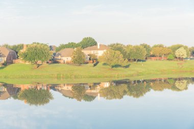Dallas, Teksas, ABD yakınlarındaki banliyö mahallesindeki cennet gibi gölü yansıtan bir bungalov evi.