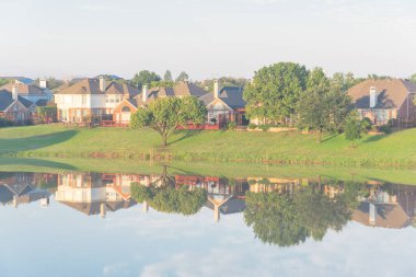 Dallas, Teksas, ABD yakınlarındaki banliyö mahallesindeki cennet gibi gölü yansıtan iki katlı bungalov evleri.