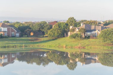 Dallas, Teksas, ABD yakınlarındaki sakin göl manzaralı banliyö evleri yansıyor.