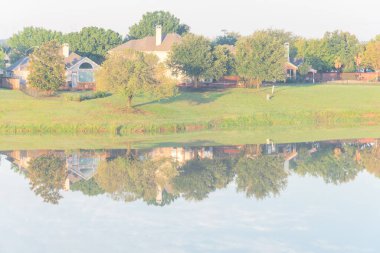 Dallas, Teksas, ABD yakınlarındaki banliyö mahallesindeki cennet gibi gölü yansıtan bir bungalov evi.
