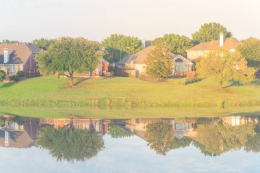 Tipik banliyö evleri Dallas, Teksas, ABD yakınlarındaki sakin gölü yansıtıyor.