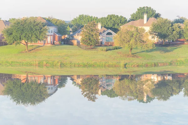 Dallas, Teksas, ABD yakınlarındaki banliyö mahallesindeki cennet gibi gölü yansıtan iki katlı bungalov evleri.
