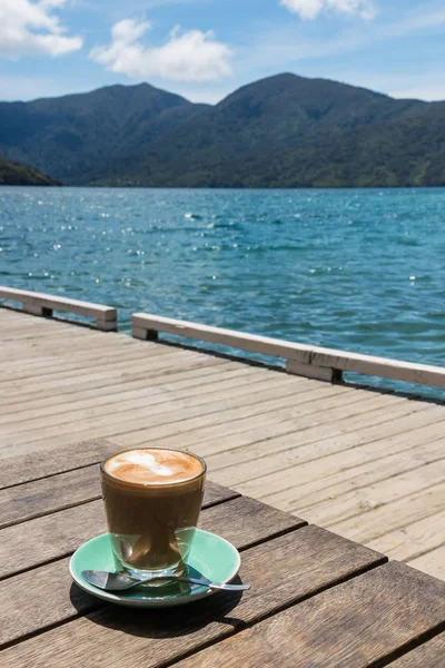 Caffe latte s molem a oceánem v pozadí — Stock fotografie