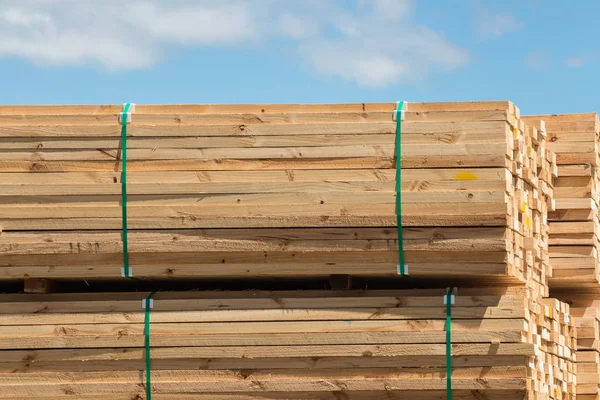 Pila de tablones de madera contra el cielo azul — Foto de Stock