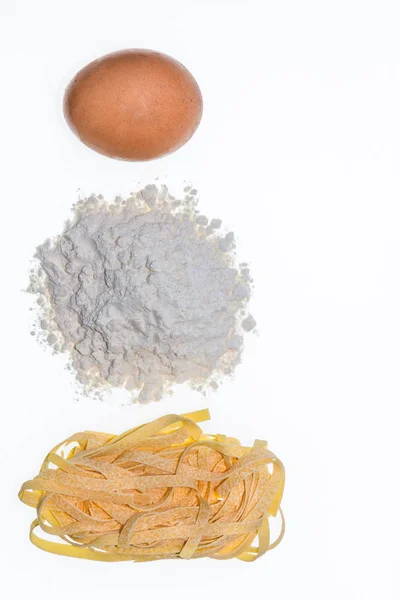 Egg, flour and tagliatelle pasta on white background — Stock Photo, Image