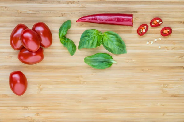 Kirschtomaten, Basilikumblätter und rote Chilischoten — Stockfoto