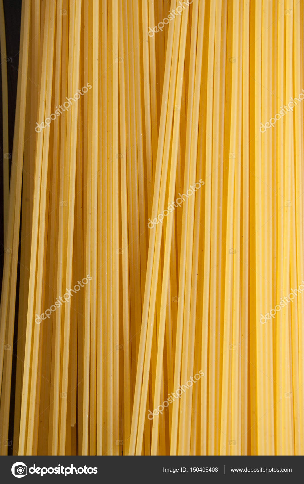 Gele lange spaghetti op zwarte achtergrond. Dunne pasta gerangschikt ... Gele lange spaghetti op zwarte achtergrond. Dunne pasta gerangschikt ...
