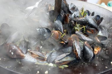 Midye hazırlanması. Bir tavada midye. Sokak gıda.