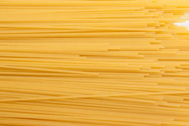 Sarı uzun spagetti. İnce makarna satırları düzenlenmiştir. Sarı İtalyan makarna. Uzun spagetti. Pişmemiş spagetti duvar kağıdı. İnce spagetti. Gıda arka plan kavramı. 