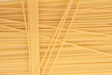 Sarı uzun spagetti. İnce makarna satırları düzenlenmiştir. Sarı İtalyan makarna. Uzun spagetti. Pişmemiş spagetti duvar kağıdı. İnce spagetti. Gıda arka plan kavramı. 