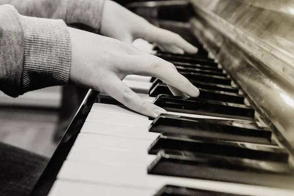 Hands of the musician on the keyboard of an piano