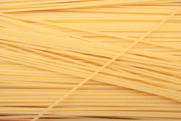 Yellow long spaghetti . Thin pasta arranged in rows. Yellow italian pasta. Long spaghetti. Raw spaghetti wallpaper. Thin spaghetti. Food background concept.