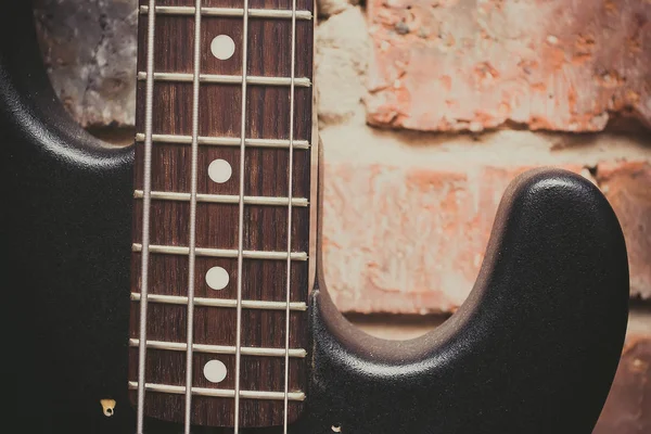Tuğla Duvar Arka Plan Üzerinde Eski Bas Gitar — Stok fotoğraf