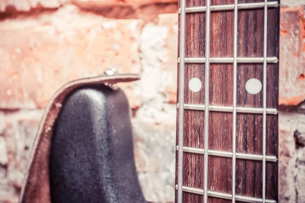 Tuğla Duvar Arka Plan Üzerinde Eski Bas Gitar — Stok fotoğraf