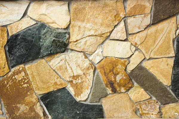 Una pared de una textura salvaje de piedra natural multicolor —  Fotos de Stock