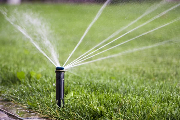 Nozzle automatic watering system against a background of green g — Stock Photo, Image