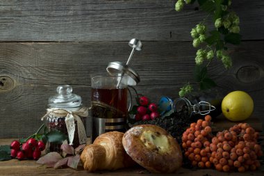 Sonbahar meyve tarafından çevrili bir ahşap zemin üzerine sıcak çay sürahi