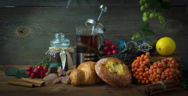 Sonbahar meyve tarafından çevrili bir ahşap zemin üzerine sıcak çay sürahi