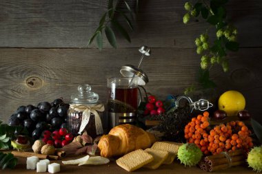 Sonbahar meyve tarafından çevrili bir ahşap zemin üzerine sıcak çay sürahi