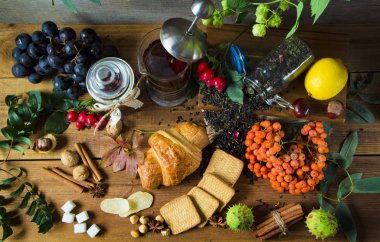 Sonbahar meyve tarafından çevrili bir ahşap zemin üzerine sıcak çay sürahi