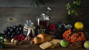 Sonbahar meyve tarafından çevrili bir ahşap zemin üzerine sıcak çay sürahi