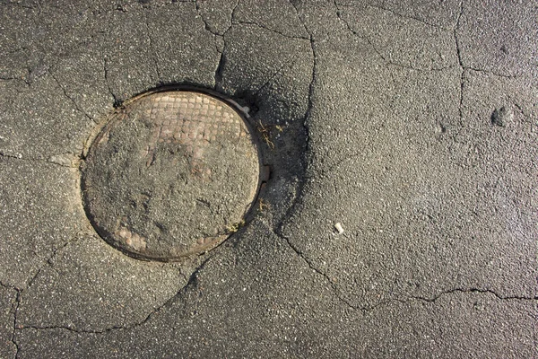 Grande buraco em asfalto e tampa de bueiro circular de esgoto bem na estrada , — Fotografia de Stock