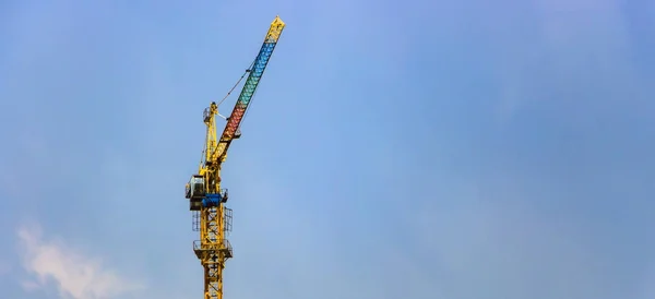 Byggkranar och höghusbyggnad under konstruktion mot blå himmel. — Stockfoto