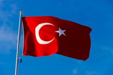 Türkiye bayrağı mavi gökyüzüne doğru dalgalanırken bayrak direğinde