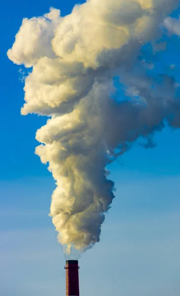 De pijp van de plant straalt schadelijke stoffen in de atmosfeer. Close-up op een hemelachtergrond — Stockfoto