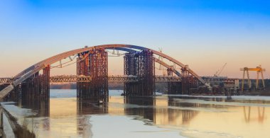 Yarım kalmış batan güneşin arka planda Dinyeper köprüden