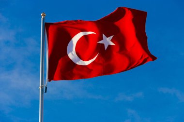 Türkiye bayrağı mavi gökyüzüne doğru dalgalanırken bayrak direğinde