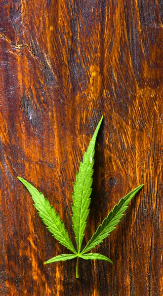 Foglie di cannabis su vecchio sfondo di legno — Foto Stock